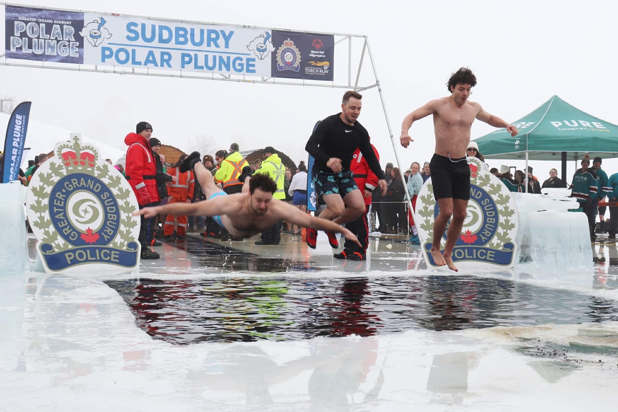 Team KING Real Estate members jumping into icy water during the Sudbury Polar Plunge 2026 charity event supporting the community.